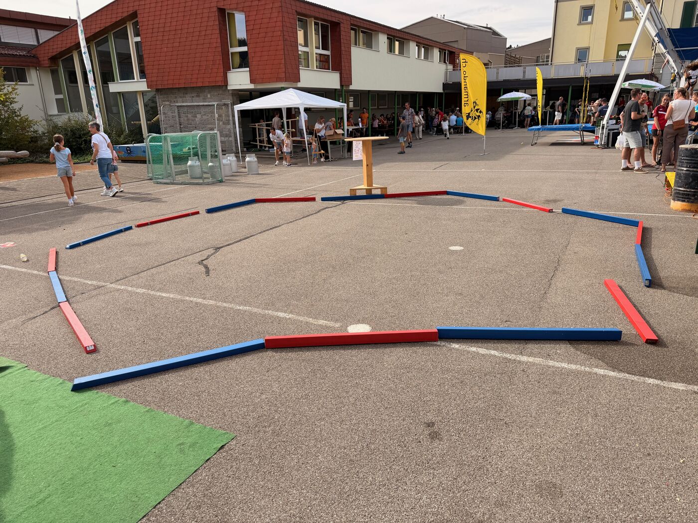Aufgebaute Arena aus roten und blauen Balken auf einem Schulhausplatz